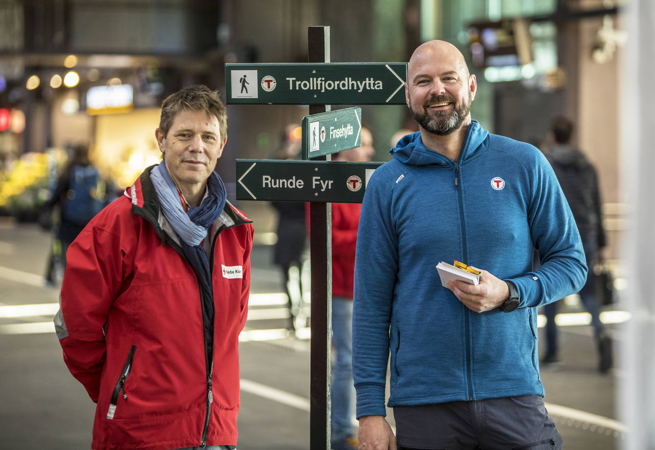 Generalsekretærene Bernt G. Apeland i Røde Kors (til venstre) og Dag Terje Solvang i DNT delte ut sjokolade og informasjon om fjellvettreglene til de reisende. Foto: Ole Berg-Rusten / NTB scanpix