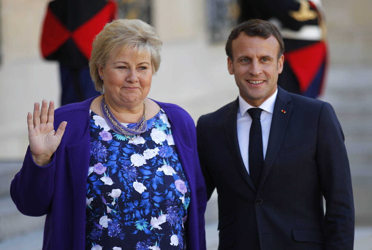 Erna Solberg uttalte seg om fødeavdelingene i Kristiansund og Molde på vei til Christchurch Summit, et toppmøte om terrorinnhold på nettet. Hun ble tatt imot av Frankrikes president Emmanuel Macron. Foto: (AP François Mori / NTB scanpix)