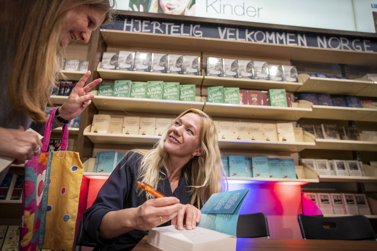 Forfatter Maja Lunde signerer den tyske oversettelsen av boken «Bienes verden» etter et bokbad i bokhandelen Ludwig i Köln, der blant andre kronprinsparet kom innom med Litteraturtoget fra Berlin. Toget fraktet 19 norske forfattere til Frankfurt og den internasjonale bokmessen. Foto: Heiko Junge / NTB scanpix