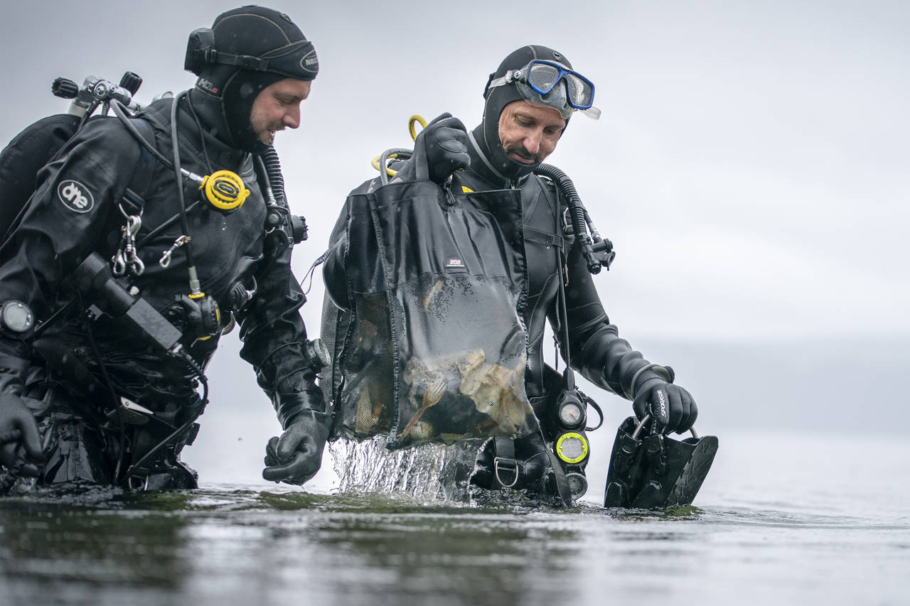 Kronprins Haakon og marinbiolog Fredrik Myhre fra WWF med plastsøppel i et nett som de har plukket opp fra havbunnen etter et dykk utenfor Sjøstrand i Asker. Illustrasjonsfoto: Heiko Junge / NTB scanpix