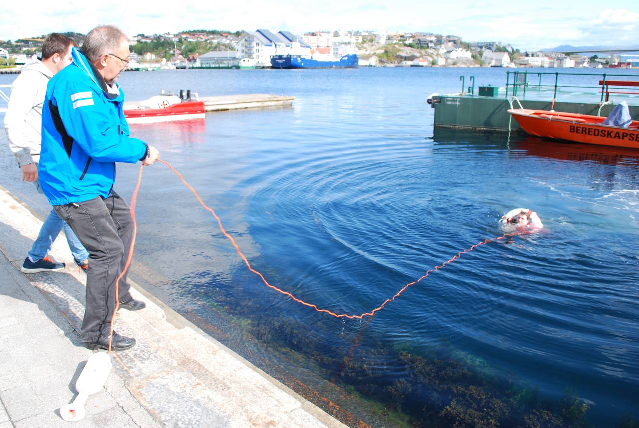 Emil Hesjevik og Kristian Rokstad i Kristiansund og Nordmøre Havn redder Arild Samuelsen Tømmervåg. Foto: Kristiansund og Nordmøre Havn