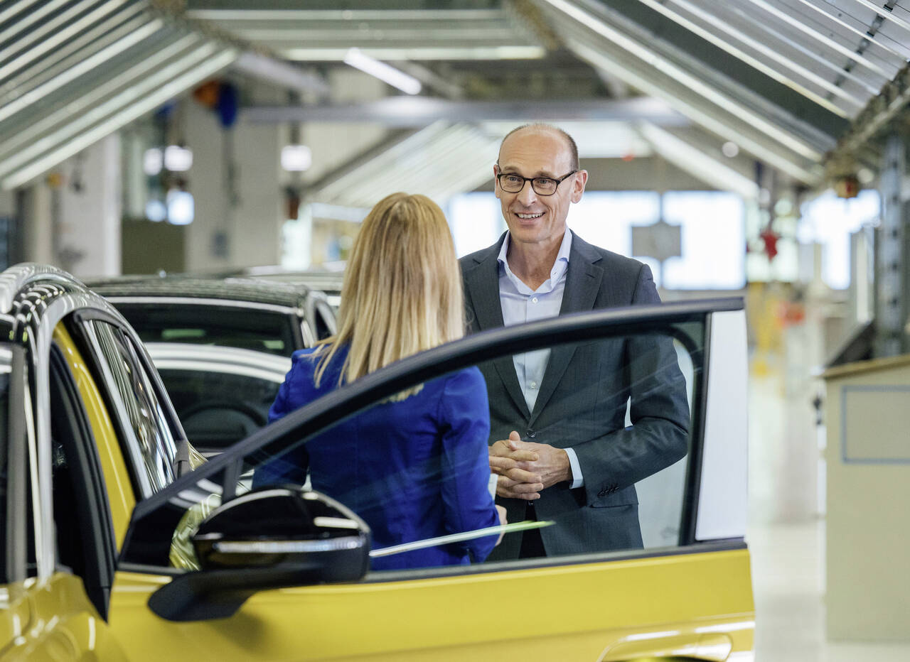 EN DØR: Volkswagen har foreløpig ikke sluppet noen andre ID. 4 bilder enn dette, av en dør og to Volkswagen-ansatte. Foto: Produsenten