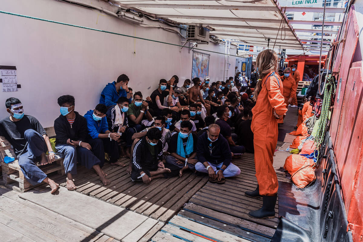 Migranter på dekk om bord på det norskeide skipet Ocean Viking søndag. Skipet har nå fått gå til kai i den italienske byen Porto Empedocle. Foto: Flavio Gasperini / SOS Méditerranée / AP / NTB scanpix