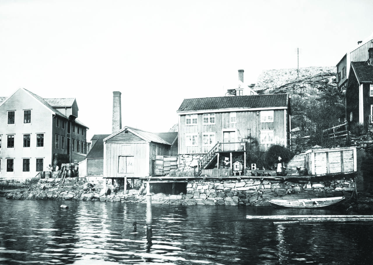 Goma Fabrikker fra 1900 fikk ferskvannsdam på 3000m3 året etter, og lagerbygning med steinkai i 1905. Familien Paulsen bodde i huset til høyre. Bilde i boken og fra Nordmøre Museums fotosamlinger.