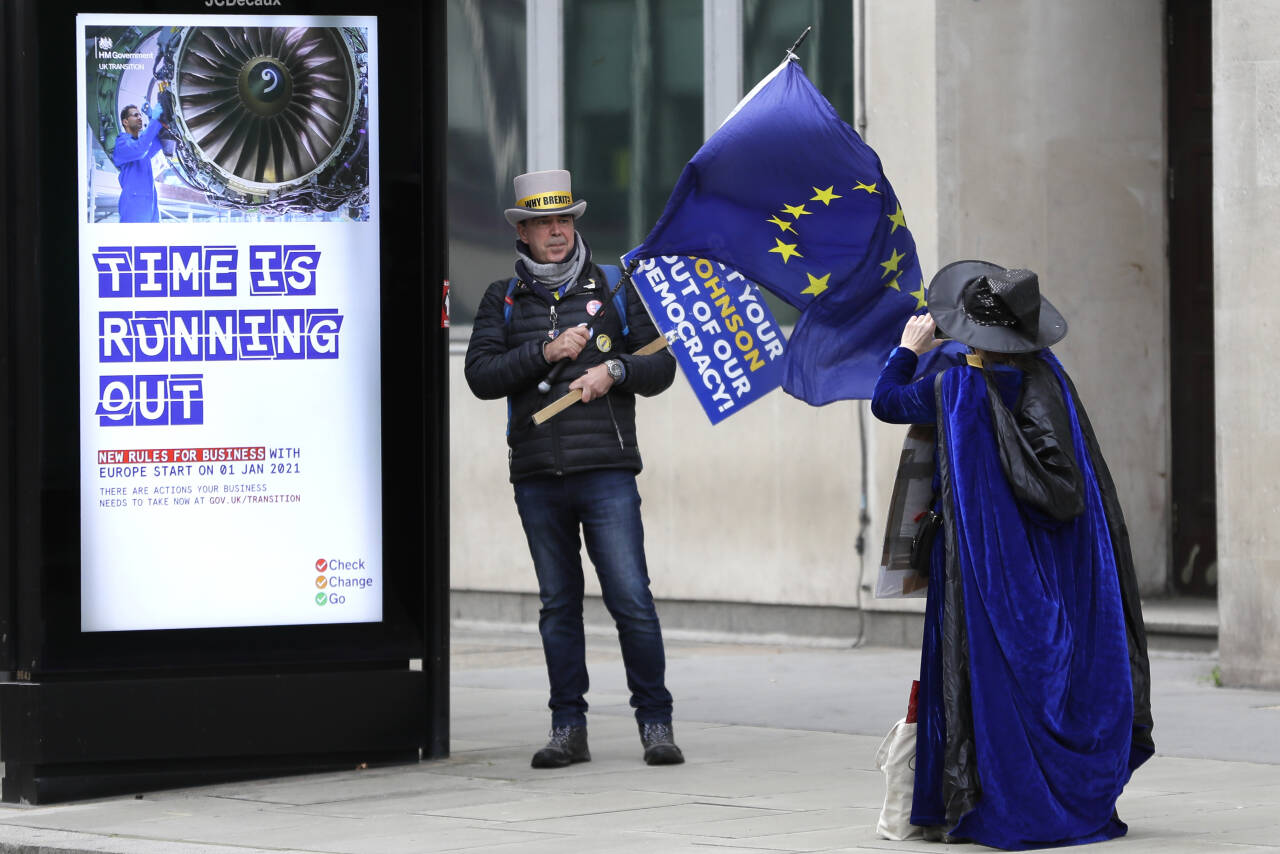 «Tiden er i ferd med å renne ut», står det på bussholdeplassen ved siden av aktivist Steve Bray, som helst skulle stoppet hele brexit. Og tiden er snart omme for Storbritannia som del av EUs indre marked. Foto: Kirsty Wigglesworth / AP / NTB