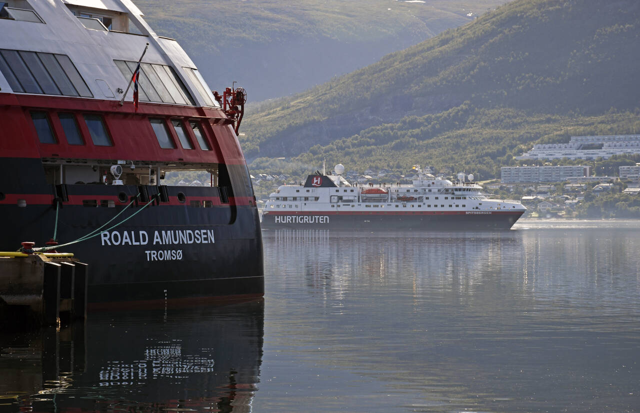 Både MS Roald Amundsen og MS Spitsbergen, her i Tromsø i august, er blant de ni skipene som nå vil stå i havn en periode. Kun to av Hurtigrutens skip vil gå langs kysten som normalt i tiden framover. Foto: Rune Stoltz Bertinussen / NTB