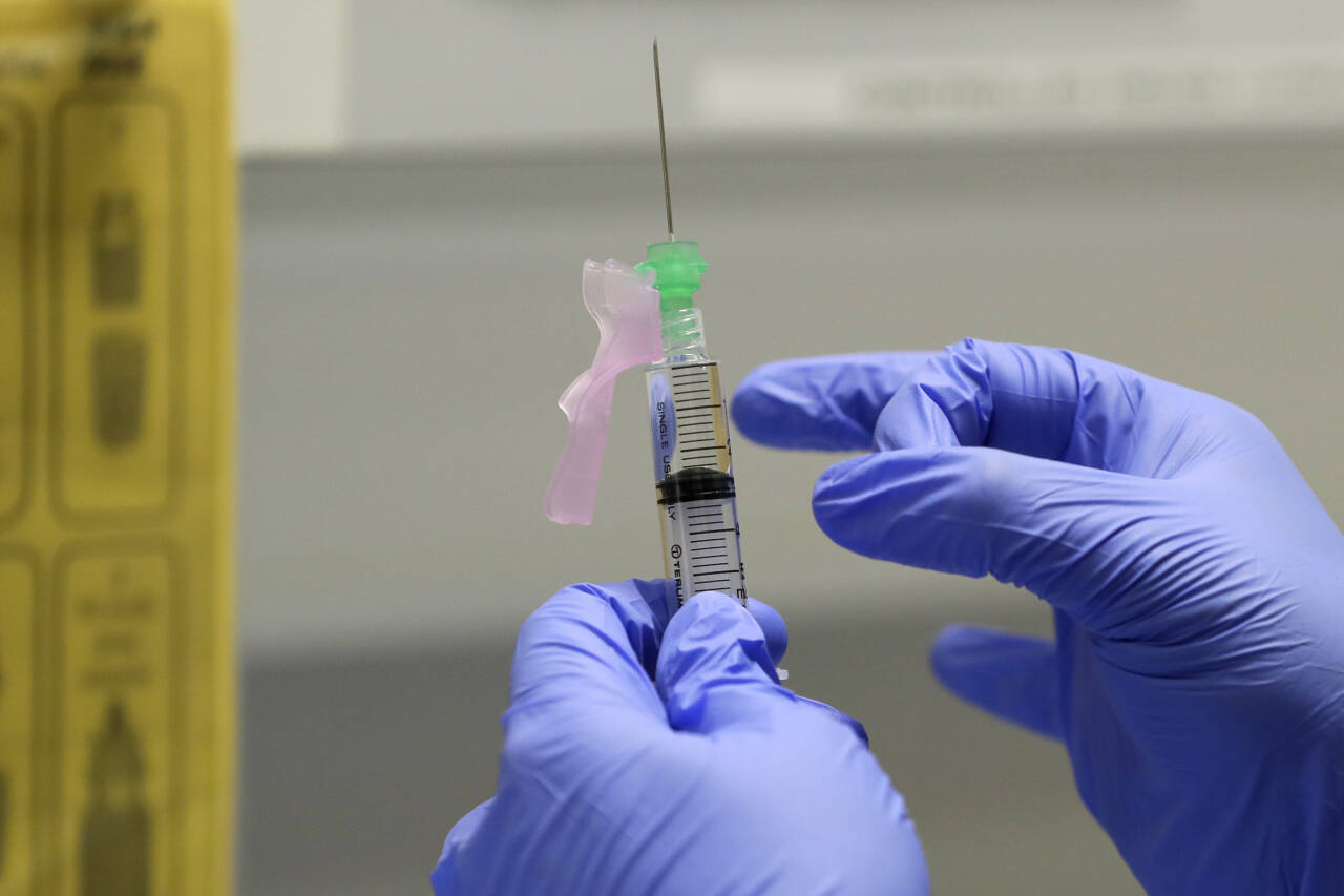 En sykepleier gjør klar en vaksinedose for utprøving på en frivillig ved en klinikk i London. Ingen koronavaksiner er så langt godkjent i Norge. Foto: Kirsty Wigglesworth / AP / NTB