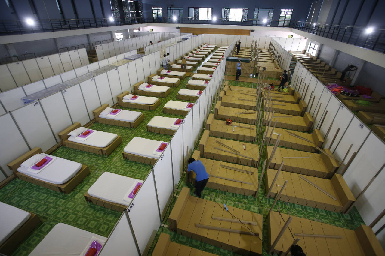 Arbeidere setter opp et feltsykehus for covid-19-pasienter i Bangkok mandag. Myndighetene i Thailand har varslet nye smitteverntiltak etter at smittespredningen har økt. Foto: Somchai Chanjirakitti / AP / NTB