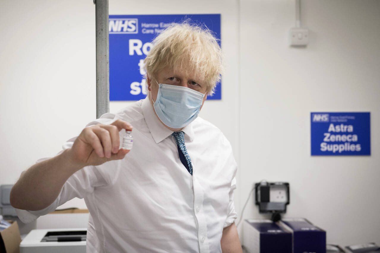Storbritannias statsminister Boris Johnson viser fram AstraZeneca-vaksinen. Foto: Stefan Rousseau / Pool Photo via AP, File / NTB