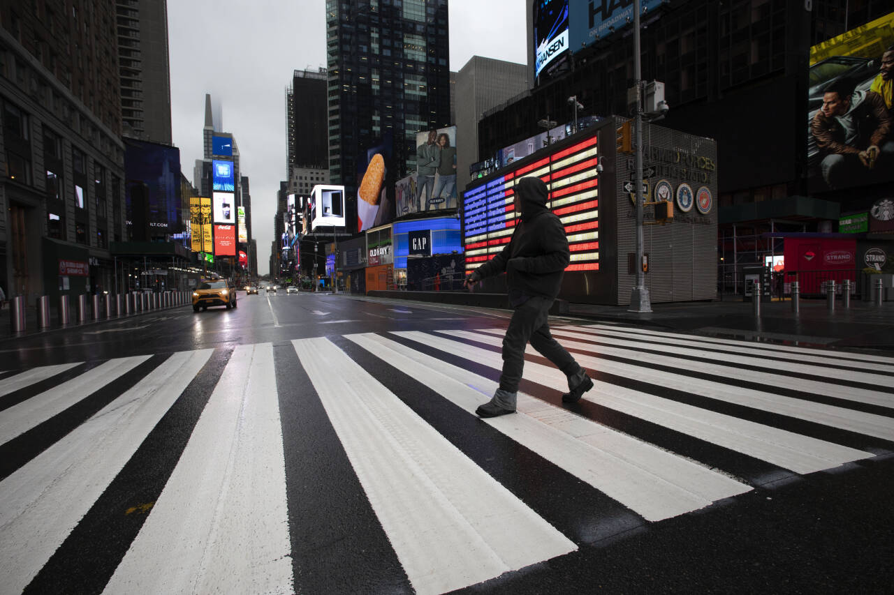 En mann krysser gaten på en nesten tom Times Square i mars i fjor. Nå har USA passert en halv million koronadødsfall. Foto: Mark Lennihan / AP / NTB