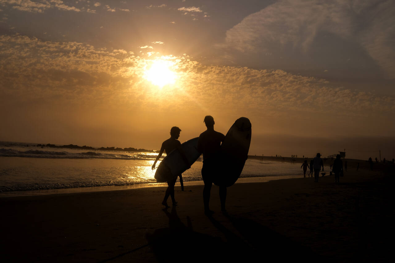 Surfere avkjøler seg som best de kan i heten på Venice Beach i Los Angeles. Foto: Ringo H.W. Chiu / AP / NTB
