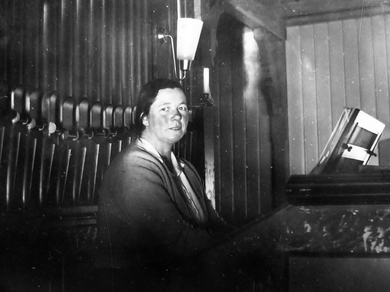 Olaug Aae ved orgelet i Kornstad kirke. Hun var organist i hele 60 år, fra 1922 til 1982. Bilde fra familien Aae