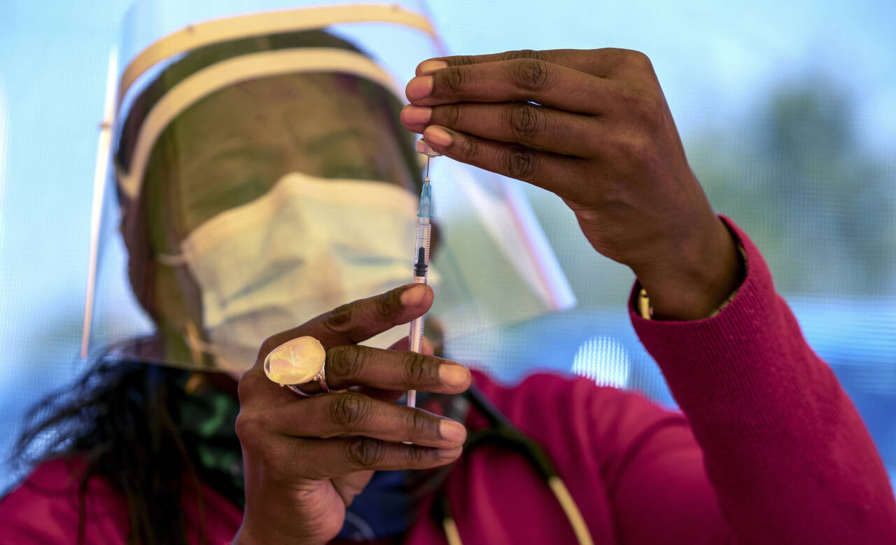 En helsearbeider forbereder en dose med Pfizer-vaksinen ved Orange Farm Clinic utenfor Johannesburg i Sør-Afrika. Svært få helsearbeidere i landet har selv fått vaksinen ennå. Foto: Themba Hadebe, AP / NTB