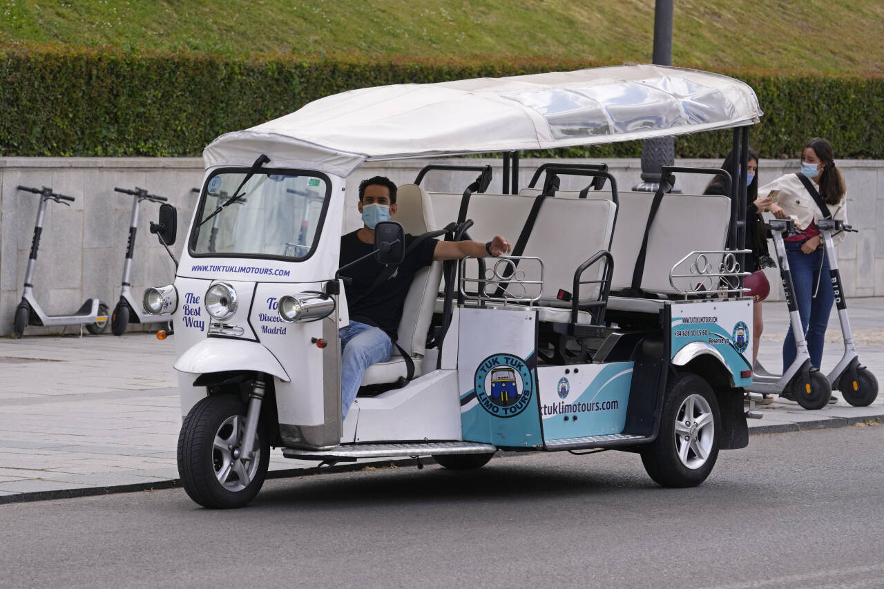 En tuk-tuk-sjåfør venter på turister i Madrid. Spania åpner mandag grensene for fullvaksinerte turister. Foto: Paul White / AP / NTB