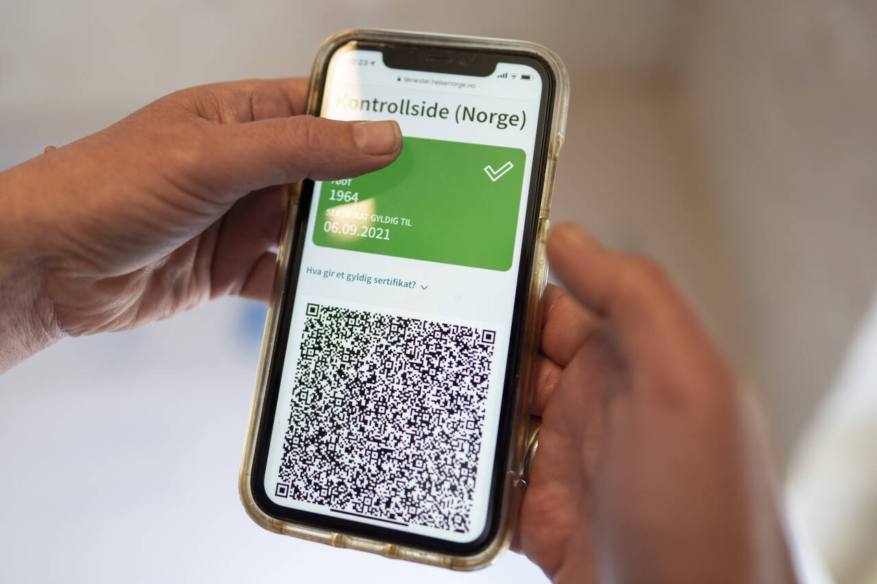 Det nye koronapasset rulles nå ut. En QR-kode i viser om en person er beskyttet. Foto: Heiko Junge / NTB