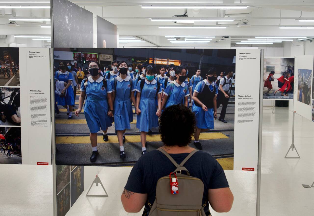 En gjest ser på et prisbelønnet bilde av demonstrasjonene i Hongkong i 2019 på en utstilling av pressebilder i Hongkong, som åpnet søndag. Foto: Vincent Yu / AP / NTB