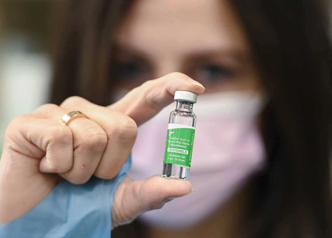 En farmasøyt viser fram et glass med AstraZenecas covid-19-vaksine. Selskapet skriver lørdag kveld at analyser så langt ikke viser noen økt risiko for blodpropp ved bruk av vaksinen. Foto: Nathan Denette/The Canadian Press/ AP/NTB