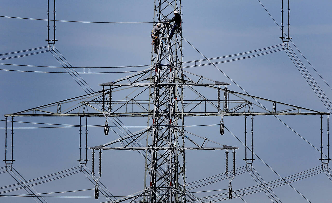 Arbeidere i en høyspentmast i Moers i Tyskland i 2011. Høye strømpriser har bidratt til å løfte inflasjonen i eurosonen. Illustrasjonsfoto: Frank Augstein / AP / NTB