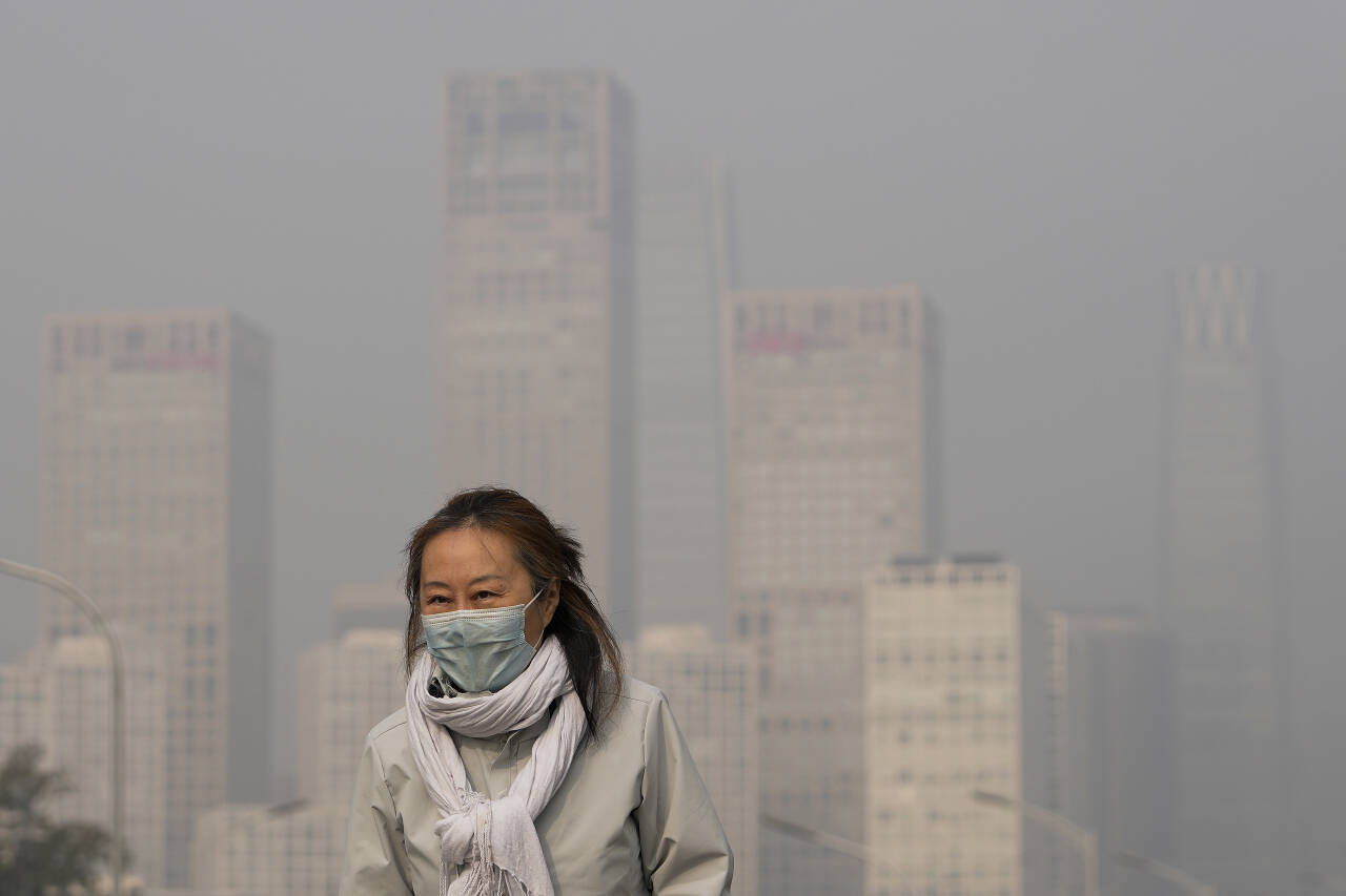 Luftforurensning plager og tar livet av millioner av mennesker verden over. WHO sier i sin siste rapport at nesten alle mennesker i verden puster inn luft som ikke oppfyller standardene for luftkvalitet. Her er en kinesisk kvinne med covid-maske som vandrer i forurensede Beijing. Foto: AP / NTB