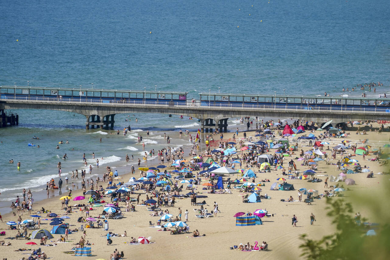 Storbritannia har fått ny varmerekord. Her er folk avbildet på stranda i Bournemouth. Foto: Steve Parsons / AP / NTB