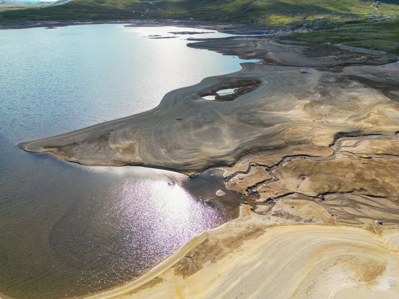 Lav vannstand i nordenden av Stegarosfjorden tidligere i sommer. Vannet henger sammen med Kalhovdfjorden, som er en del av flere regulerte vann sør på Hardangervidda. Foto: Ørn E. Borgen / NTB