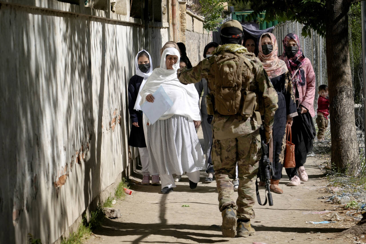 En talibansoldat stanser kvinner som ønsker å gå inn på regjeringens passkontor. Kvinner har fått sterke begrensninger i sin reisefrihet under talibanstyret Foto: Ebrahim Noroozi / AP / NTB