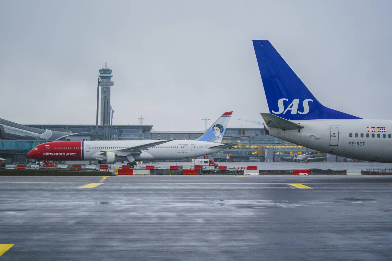 Norwegian-fly og SAS-fly på Oslo lufthavn. Flytrafikken er i ferd med å hente seg inn igjen etter nedstengningen i 2021. Foto: Stian Lysberg Solum / NTB