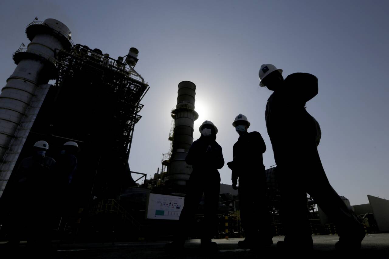 Saudi Aramco-arbeidere foran en gassturbin i oljefeltet Khurais utenfor Riyadh i Saudi-Arabia i 2021. Foto: Amr Nabil / AP / NTB