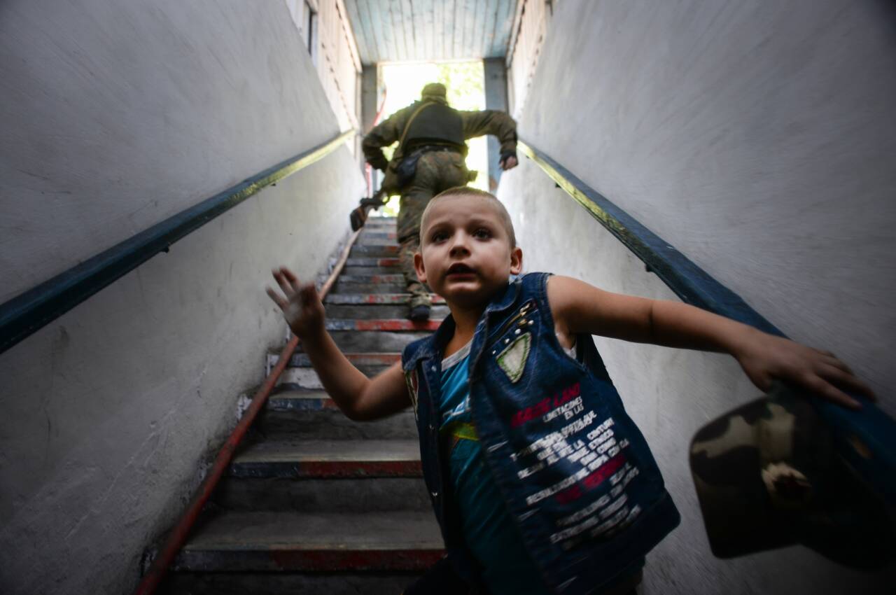 Illustrasjonsfoto fra Ukraina med barn på vei til tilfluktsrom etter varsel om bombe/rakettangrep. Foto: Mstislav Chernov / AP