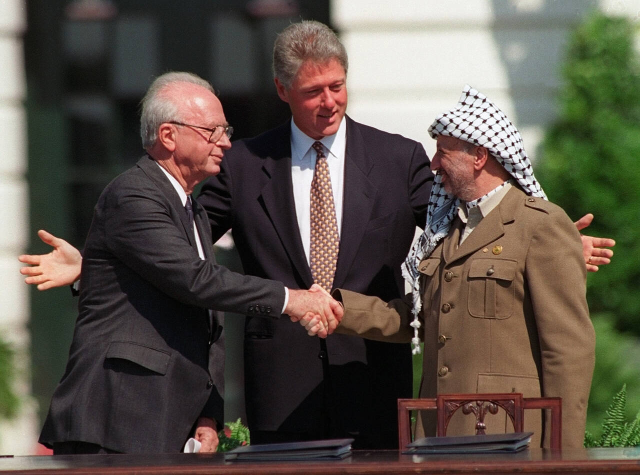 Israels statsminister Yitzhak Rabin og palestinernes leder Yasser Arafat forseglet Oslo-avtalen med et håndtrykk på plenen utenfor Det hvite hus i Washington 13. september 1993, med president Bill Clinton som vitne. Fred resulterte avtalen ikke i. Foto: AP / NTB 