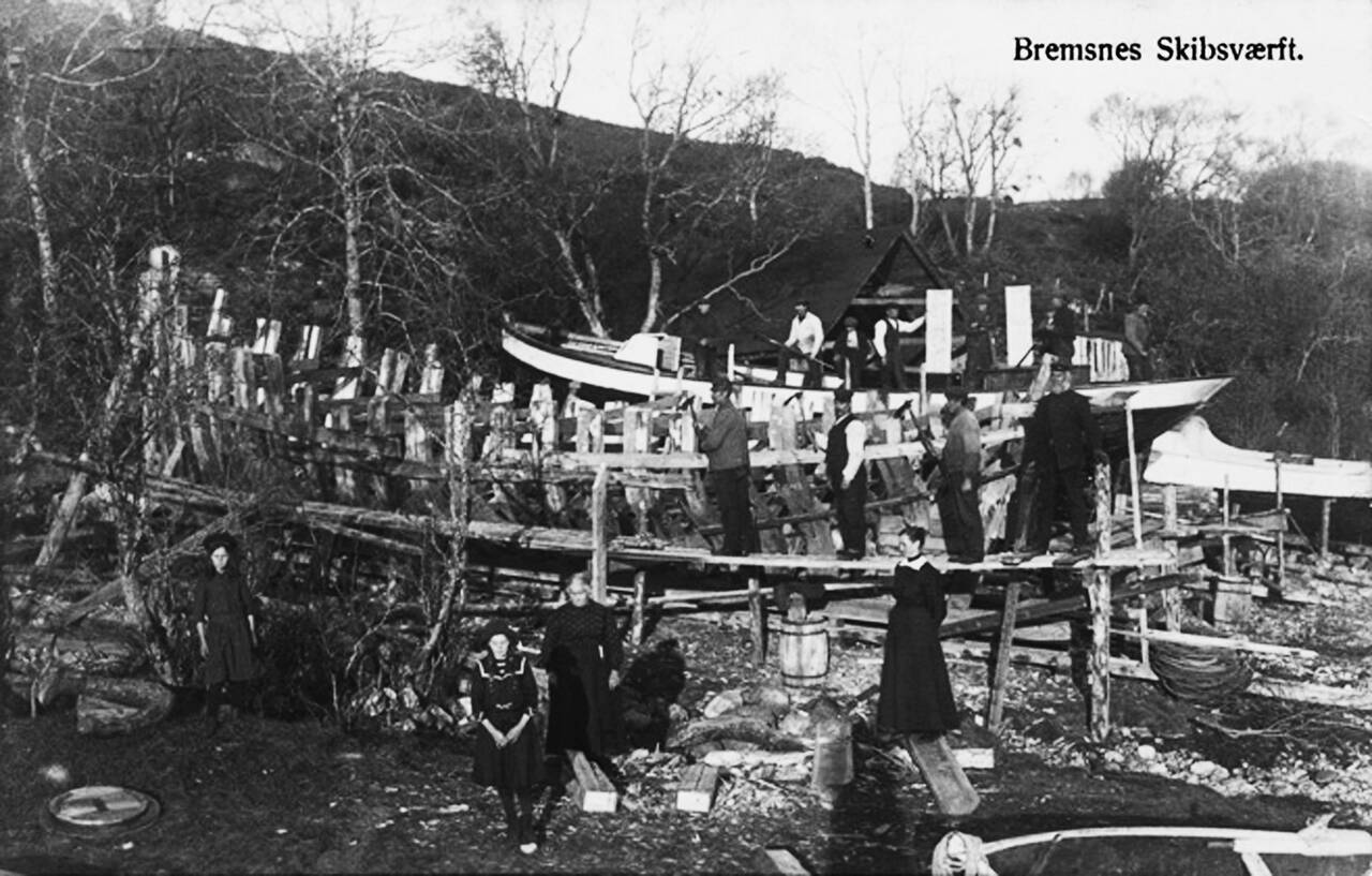 Fra Bremsnes Båtbyggeri etter etableringen i 1914. Båten som nærmer seg ferdigstillelse ble overlevert til Koplo Kristiansen på Grip. Båten nærmest fikk navnet «Nordstjernen». Vi ser båtbygger Oluf Dahlen med hvite skjorteermer foran på bildet. (Nordmørsmusea)