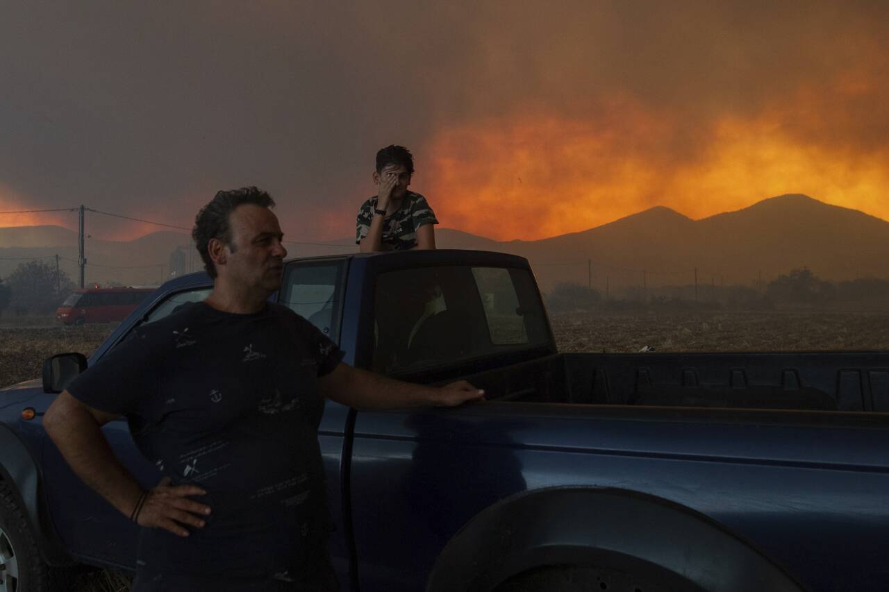 Lokale innbyggere følger med på en skogbrann i nærheten av Alexandroupoli i Hellas 21. august i fjor. Skogbrannen her var den største som noen gang er registrert i EU. Klimaendringene bidrar til økt skogbrannfare mange steder i verden. Foto: Achilleas Chiras / AP / NTB