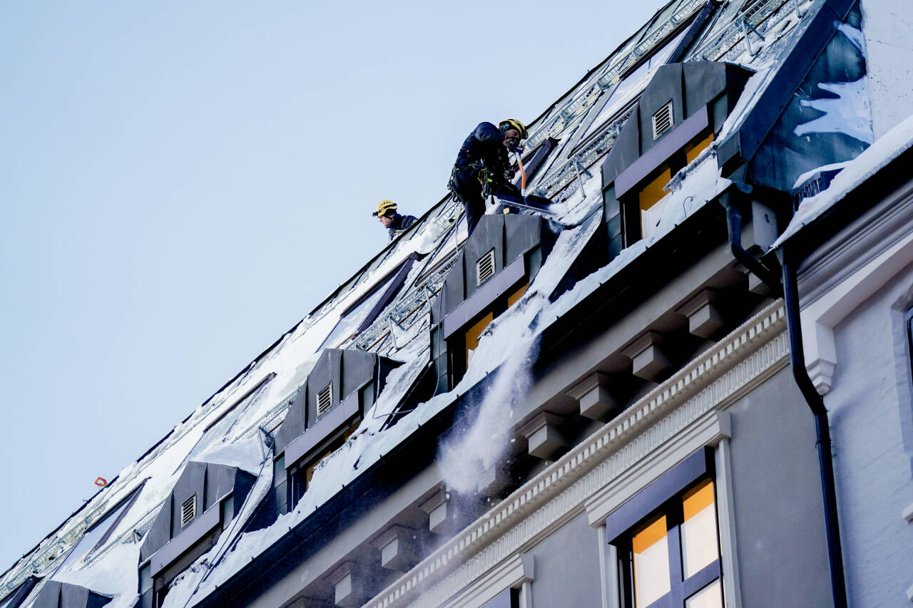 En mann jobber med å fjerne snø og is fra et tak i Oslo sentrum. 6 prosent flere vurderer å bytte jobb enn på samme tid i fjor, viser en undersøkelse fra Opinion. Foto: Fredrik Varfjell / NTB