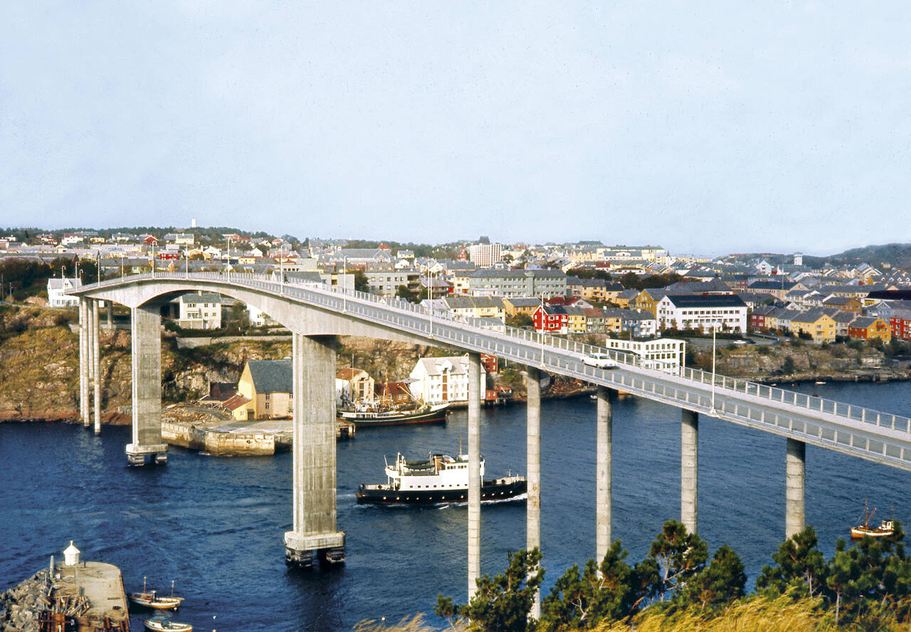 Sørsundbrua i 1964 med Bremsnesferja «Gjemnes» i rute under brua. Foto: Gunnar Stokke