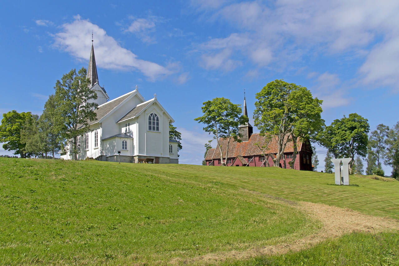 Begge kirkene er godt synlig på Kvernes. Kvernes kirke ble bygd i 1893 og er også en historisk kirke. Foto: Terje Holm