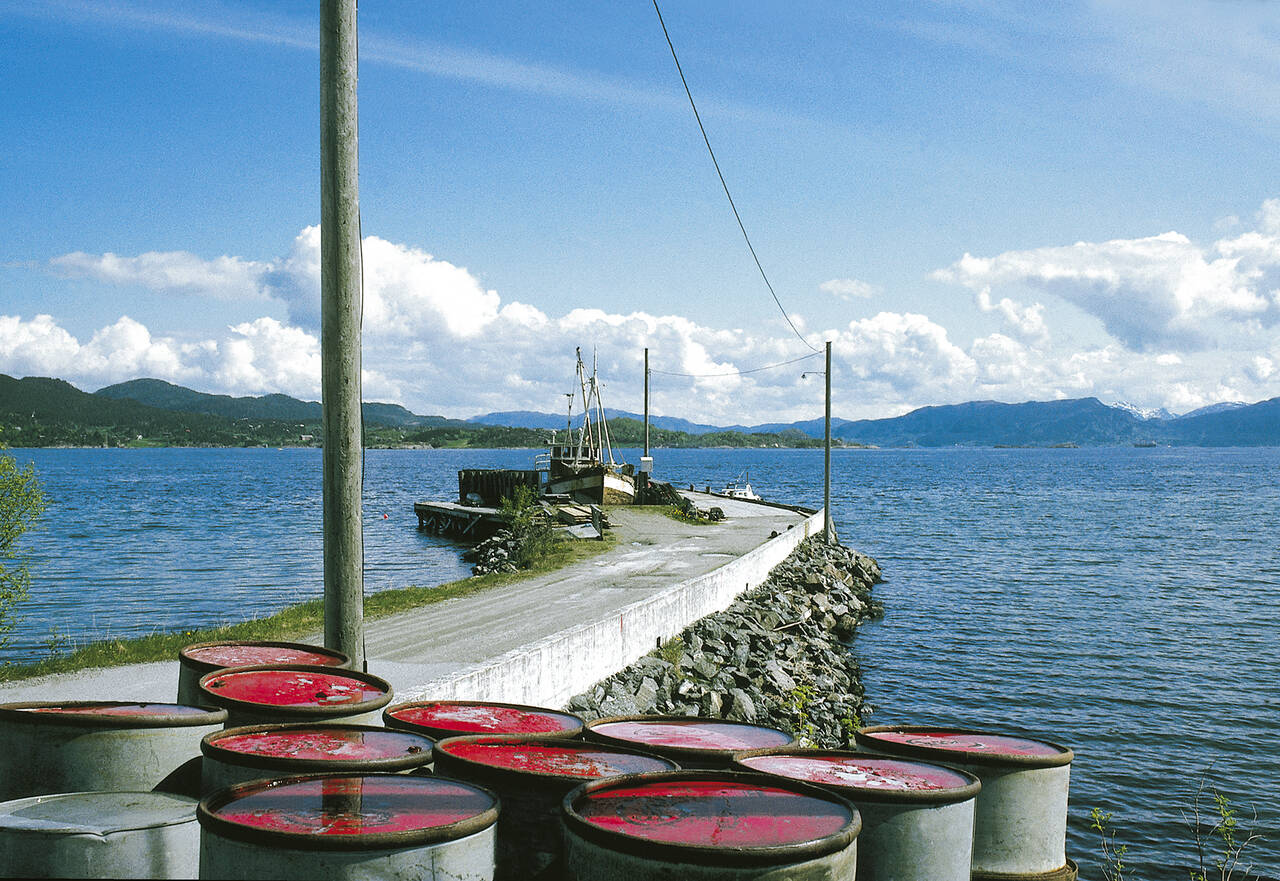 Etter nedleggelsen i 1962 ble Kvernes ferjekai brukt som kai for mindre fiskebåter. Her ser vi den gamle ferjekaia først på 1980-tallet før den ble revet for å kunne lage småbåthavn. Foto: Terje Holm