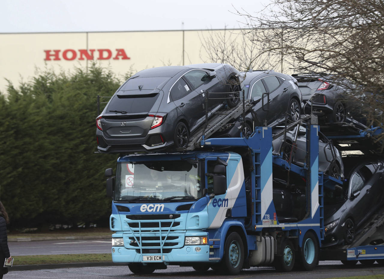 Et vogntog forlater Hondas fabrikk i Swindon. Den japanske bilgiganten ventes tirsdag å kunngjøre nedleggelsen av fabrikken, som er Hondas eneste i EU. Foto: Steve Parsons / AP / NTB scanpix