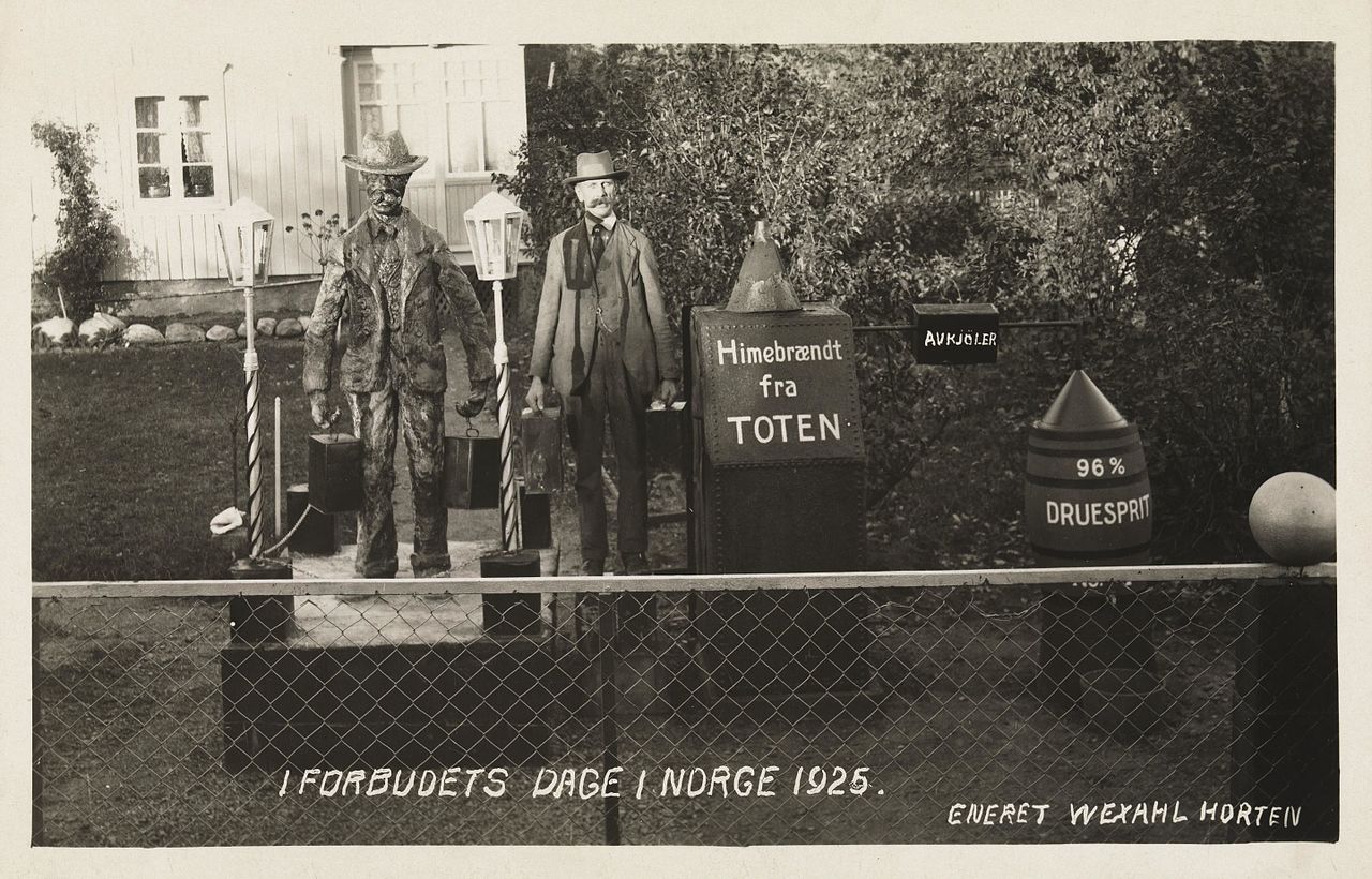 «I forbudets dage i Norge 1925», humoristisk postkort med blant annet kanner for hjemmebrent. 1916-1927 var det i Norge forbud mot produksjon, import, transport, omsetning og skjenking av brennevin. Foto: utgiver: Wexahl, Horten / Nasjonalbiblioteket