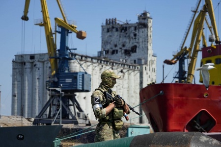 En russisk soldat står vakt ved havnen i Mariupol, som nå er under russisk kontroll. Bygget i bakgrunnen er et kornlager. Russiske blokader av havnene i Ukraina gjør det umulig å eksportere korn fra landet. Arkivfoto: AP / NTB