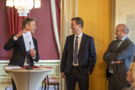 Energiminister Terje Aasland (Ap) med Peter van der Poel, administrerende direktør i Ingka (i midten) og François van Leeuw, konsernsjef i Parkwind, viser fram den nylig signerte kontrakten om utbyggingen av havvind i området Sørlige Nordsjø II. Foto: Heiko Junge / NTB