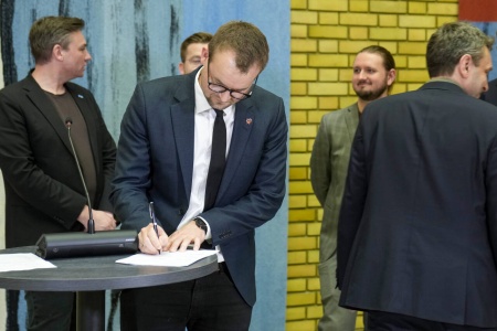 Kjell Ingolf Ropstad (KrF) signerer under pressekonferansen i vandrehallen etter at et flertall på Stortinget har blitt enige om et forlik om en ny pensjonsreform. Foto: Fredrik Varfjell / NTB