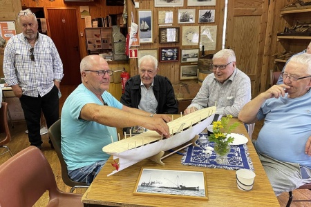 Magne Otterlei viser modellskroget til «Veslegut» i samtale med Einar Bøe (bestmann på båten i mange år), Jostein Foss og Peder Sæther. Bak til venstre Inge Dønheim. Foto: Bernt Bøe