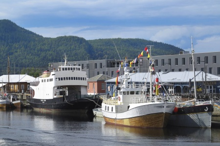 Ferja «Holger Stjern» (1958) og den tidligere fiskebåten «Tubåen» ved Fosenkaia i Trondheim i slutten av juli 2024. Bak «Tubåen» ser vi litt av «Værdalen». Foto: Terje Holm