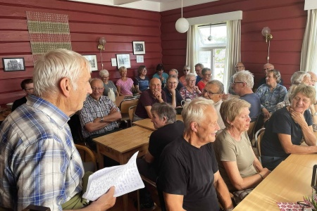 Folksamt: Tett rundt borda i den gamle skulestua på Årnes når Svein ønskjer vel møtt. Foto: Bernt Bøe